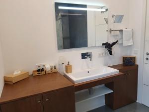 a bathroom with a sink and a mirror at Zum kleinen Italiener - Ristorante Pizzeria Pension in Geinberg