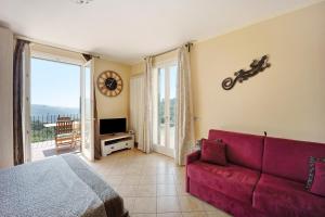 een woonkamer met een rode bank en een balkon bij Maison Laura in Diano Borello