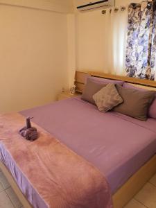 a bedroom with a large bed with purple sheets at Villa Raven`s Paradise (Lavender) in Willemstad