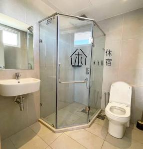 a bathroom with a shower and a toilet and a sink at KYU Suites-Aru Suites, Tg Aru Seaview 3BR in Kota Kinabalu