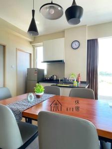 a kitchen with a wooden table and chairs with writing on it at KYU Suites-Aru Suites, Tg Aru Seaview 3BR in Kota Kinabalu