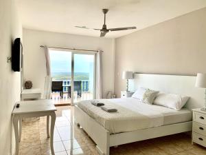 a white bedroom with a bed and a balcony at Hotel Eclipse, Playa Coronado in Playa Coronado