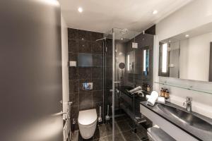 a bathroom with a toilet and a sink and a mirror at Best Western Plus Hotel Ilulissat in Ilulissat