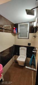 a small bathroom with a toilet and a mirror at CITY HOMES PARADISE APARTMENT in Mumbai