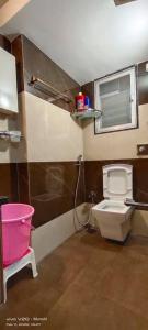 a small bathroom with a toilet and a window at CITY HOMES PARADISE APARTMENT in Mumbai