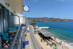 a balcony of a building with a street and the ocean at Perla Apartments in Agios Nikolaos