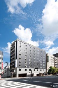 a large white building on a city street at Hotel Kyoto Base in Kyoto