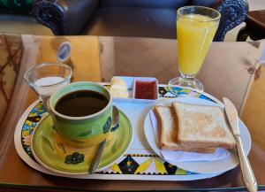 un vassoio con una tazza di caffè e un piatto con pane tostato e succo di frutta di Residencial Uruguay a La Paz