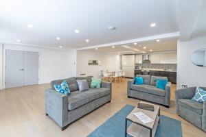 a living room with two couches and a kitchen at 4 Bedroom Holiday Home in Bolton, Appleby-in-Westmorland in Kirkby Thore