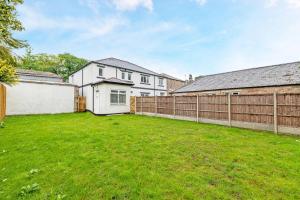 a yard with a fence and a white house at 4 Bedroom Holiday Home in Bolton, Appleby-in-Westmorland in Kirkby Thore