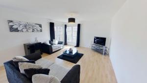 a living room with a couch and a tv at Orange Apartments Bothwell Road in Aberdeen