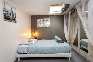ein kleines Schlafzimmer mit einem Bett und einem Fenster in der Unterkunft L'harmonie in Amiens