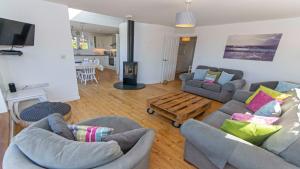 a living room with two couches and a wooden coffee table at Rooftops Braunton, Stylish Beach House - Fantastic Views - Hot Tub hire - Sleeps 8 in Braunton