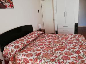 a bedroom with a bed with a floral bedspread at Zigal hotel in Antofagasta