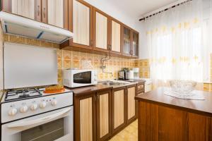 a kitchen with a white stove and a microwave at Apartment AdriaHouse in Punat