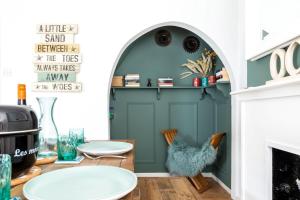 a living room with a green door and a fireplace at Sprite Cottage, in the heart of Whitstable in Whitstable