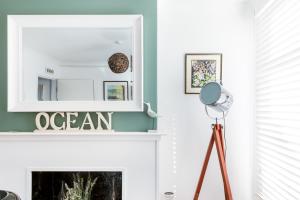 a living room with a fireplace and a mirror at Sprite Cottage, in the heart of Whitstable in Whitstable