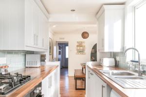 a kitchen with white cabinets and a sink at Sprite Cottage, in the heart of Whitstable in Whitstable +34 photos