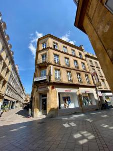 un grand bâtiment dans une rue d'une ville dans l'établissement Hôtel du Centre, à Metz