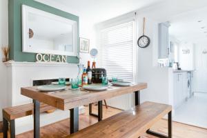 a dining room with a table and a fireplace at Sprite Cottage, in the heart of Whitstable in Whitstable