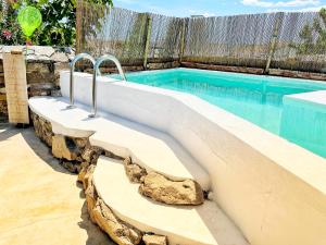 - une piscine avec un rocher au bord de celle-ci dans l'établissement Villa Oliva São Pedro, à São Pedro do Corval