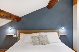 a bed with two pillows and a blue wall at Bellavista in Chiesa in Valmalenco