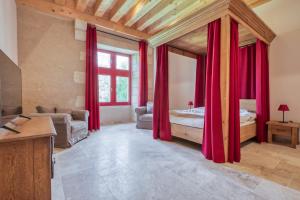 - une chambre avec des rideaux rouges et un lit dans un dortoir dans l'établissement Château de Vieux Moulin, 