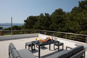 a table with food and drinks on a patio at Zlatni Rat Beach Resort in Bol