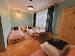 een kamer met twee bedden en een tafel erin bij Daglezja in Przyborów