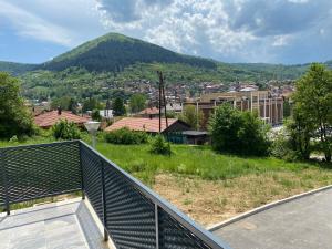 uma varanda com vista para uma cidade e uma montanha em New Apartment in the City em Visoko