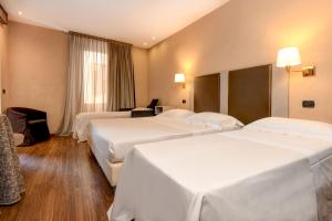 Postel nebo postele na pokoji v ubytování Hotel Tripoli