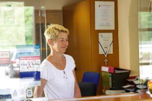 Eine Frau, die an einem Tresen in einem Laden steht. in der Unterkunft Landgasthof Pauliwirt in Erharting