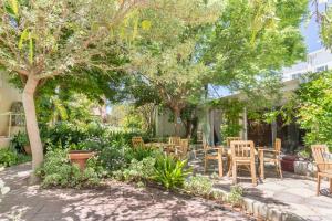 a patio with tables and chairs under trees at Montagu Country Hotel in Montagu +180 photos