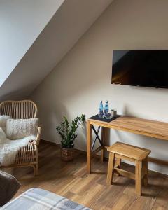 uma sala de estar com uma secretária e uma televisão na parede em Bacówka Polany em Polany