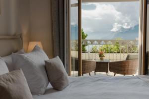Schlafzimmer mit einem Bett und Blick auf einen Balkon in der Unterkunft Le Mirador Resort & Spa in Vevey