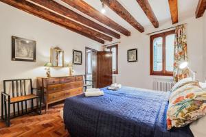 1 dormitorio con cama azul y techo de madera en Piazza San Marco Cozy Apartment x4, en Venecia