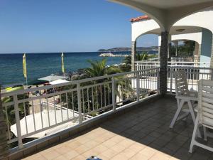 a balcony with two chairs and a view of the ocean at THASSOS LOVELY MAISONETTE BY THE SEA in Potos