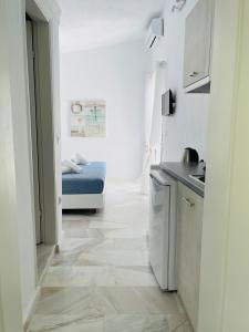 a small white kitchen with a bed in a room at Lefki villa in Polykhrono