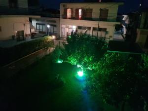 a swimming pool at night with green lights at MAGDALINOS APARTMENTS (3) in Nea Skioni