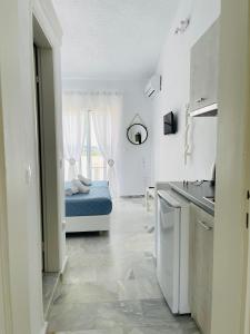 a white kitchen with a bed in a room at Lefki villa in Polykhrono