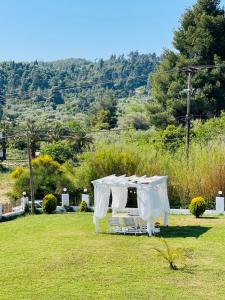 a white table and chairs in a field at Lefki villa in Polykhrono