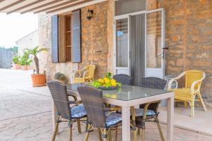 Une table à manger et des chaises sont disponibles sur la terrasse. dans l'établissement Sa Punta -Sa Punta Bertumins-, à Ses Salines
