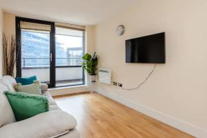 a living room with a couch and a flat screen tv at Vivid Apartment in Central London in London