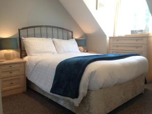 a bedroom with a large bed with a blue blanket at ** SPECIAL OFFER ** Half price - Book your Double room with us now in Willand