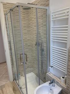 W łazience znajduje się szklana kabina prysznicowa i umywalka. w obiekcie Ca' da Màia w mieście La Spezia