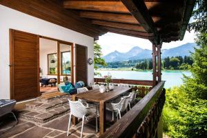 d'une terrasse avec une table et des chaises et une vue sur le lac. dans l'établissement Ferienhaus Faakersee Hideaway am See, à Faak am See