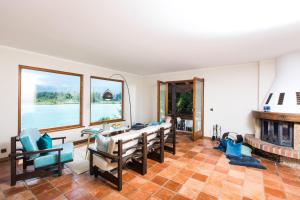 ein Wohnzimmer mit einem Tisch, Stühlen und einem Kamin in der Unterkunft Ferienhaus Faakersee Hideaway am See in Faak am See