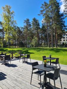 een groep tafels en stoelen op een patio bij Viesu nams UPE in Roja