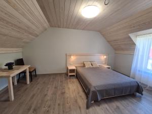 a bedroom with a bed and a wooden ceiling at Viesu nams UPE in Roja