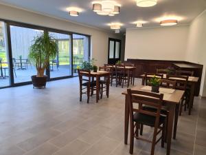 een restaurant met tafels en stoelen en een potplant bij Viesu nams UPE in Roja